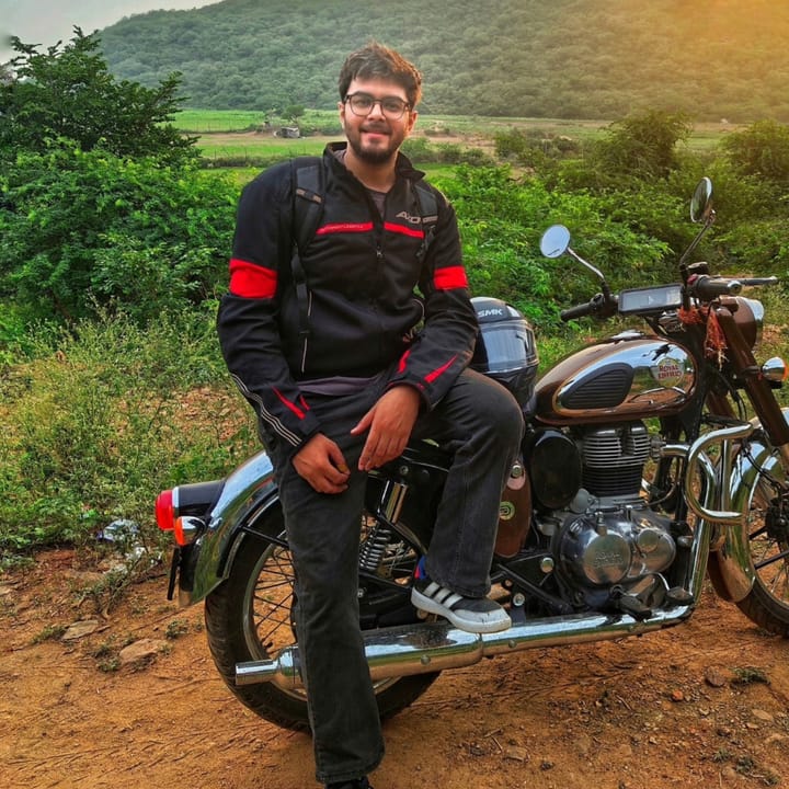 On a Royal Enfield Classic on a dirt track at golden hour